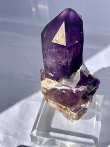Goboboseb Mountains. Erongo Region, Namibia.  Weight: 180.5 grams  Dimensions: L 5 x W 4 inches x 2.75 inches  Holy smokes this is such an insane piece. Pockets of chalcedony adorn this gorgeous Amethyst point. This baby glows bright green under short wave. Theres pieces that come along once in a lifetime and we consider this to be one of them. Custom stand is included.