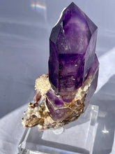 Load image into Gallery viewer, Goboboseb Mountains. Erongo Region, Namibia.  Weight: 180.5 grams  Dimensions: L 5 x W 4 inches x 2.75 inches  Holy smokes this is such an insane piece. Pockets of chalcedony adorn this gorgeous Amethyst point. This baby glows bright green under short wave. Theres pieces that come along once in a lifetime and we consider this to be one of them. Custom stand is included.
