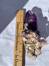 Load image into Gallery viewer, Goboboseb Mountains. Erongo Region, Namibia.  Weight: 180.5 grams  Dimensions: L 5 x W 4 inches x 2.75 inches  Holy smokes this is such an insane piece. Pockets of chalcedony adorn this gorgeous Amethyst point. This baby glows bright green under short wave. Theres pieces that come along once in a lifetime and we consider this to be one of them. Custom stand is included.

