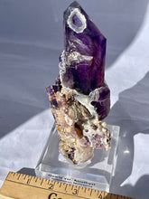 Load image into Gallery viewer, Goboboseb Mountains. Erongo Region, Namibia.  Weight: 180.5 grams  Dimensions: L 5 x W 4 inches x 2.75 inches  Holy smokes this is such an insane piece. Pockets of chalcedony adorn this gorgeous Amethyst point. This baby glows bright green under short wave. Theres pieces that come along once in a lifetime and we consider this to be one of them. Custom stand is included.
